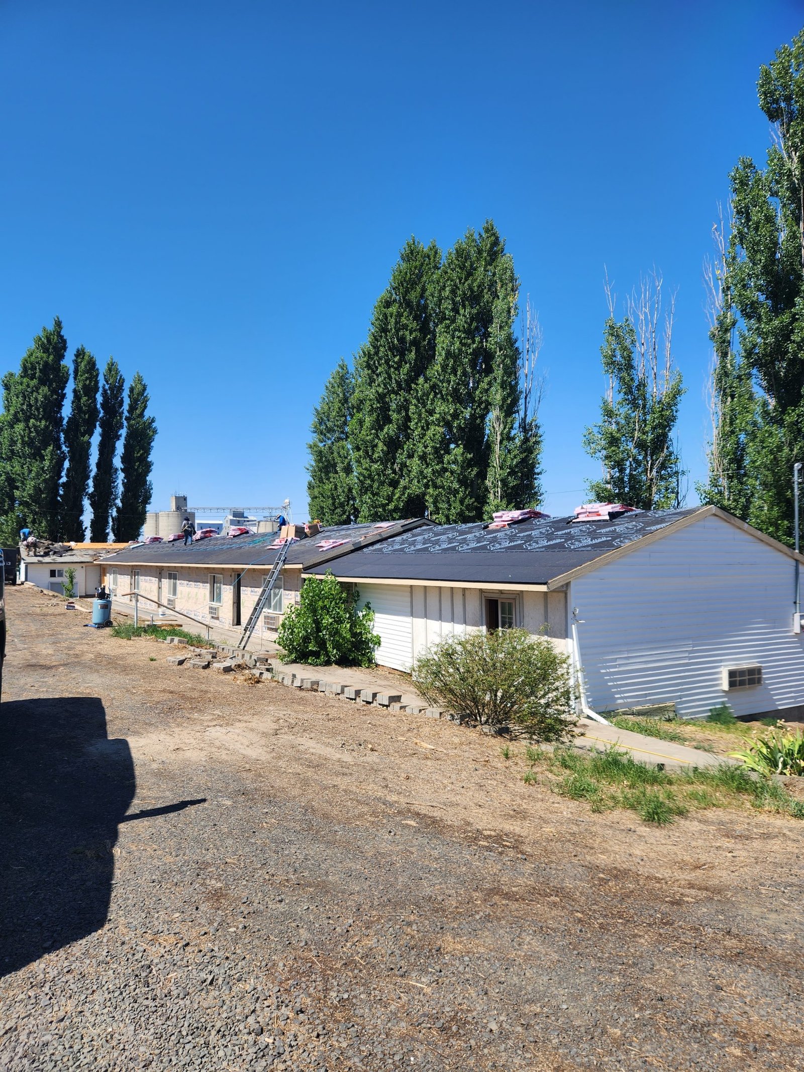 Roofing team installing underlayment on building