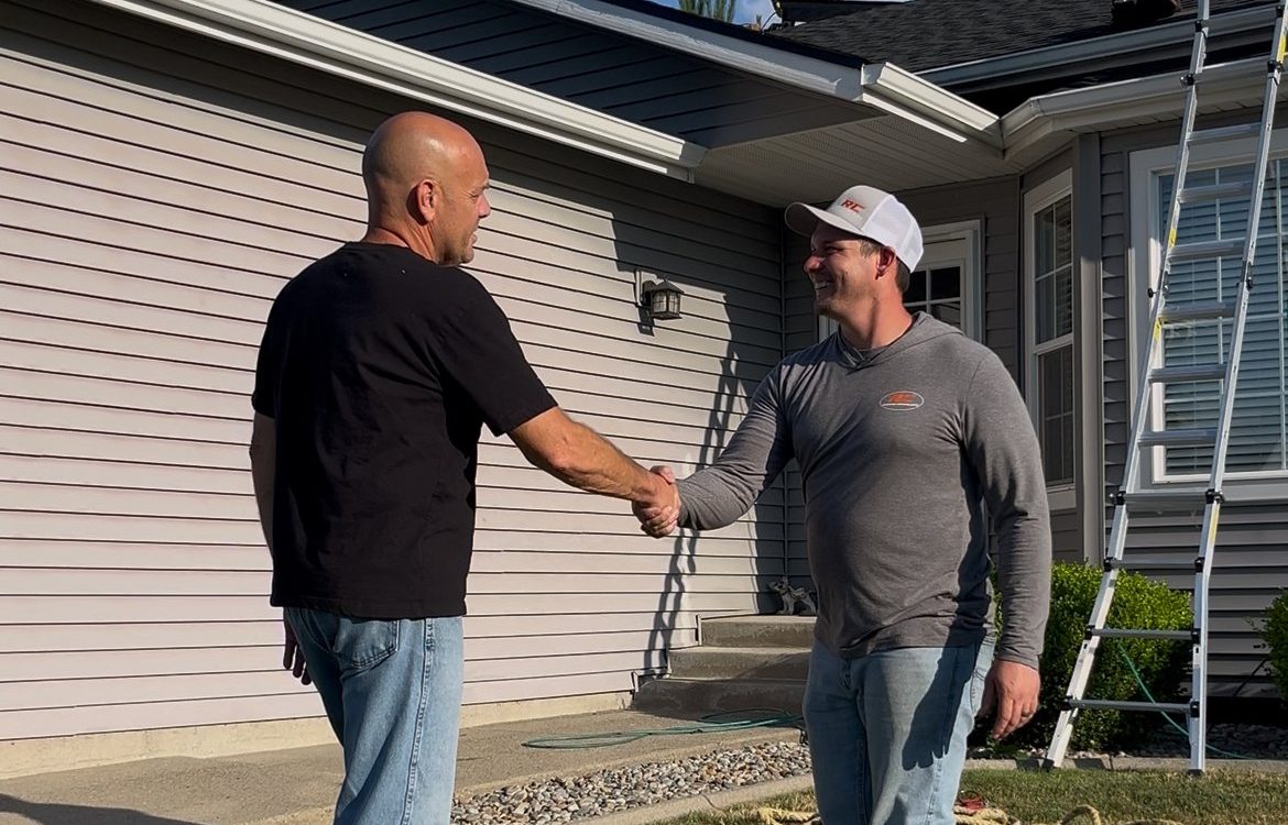 Josh honald owner of RC Roofing Specialists shaking a satisfied homeowners hand