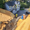 RC Roofing crew installing underlayment on a residential roof